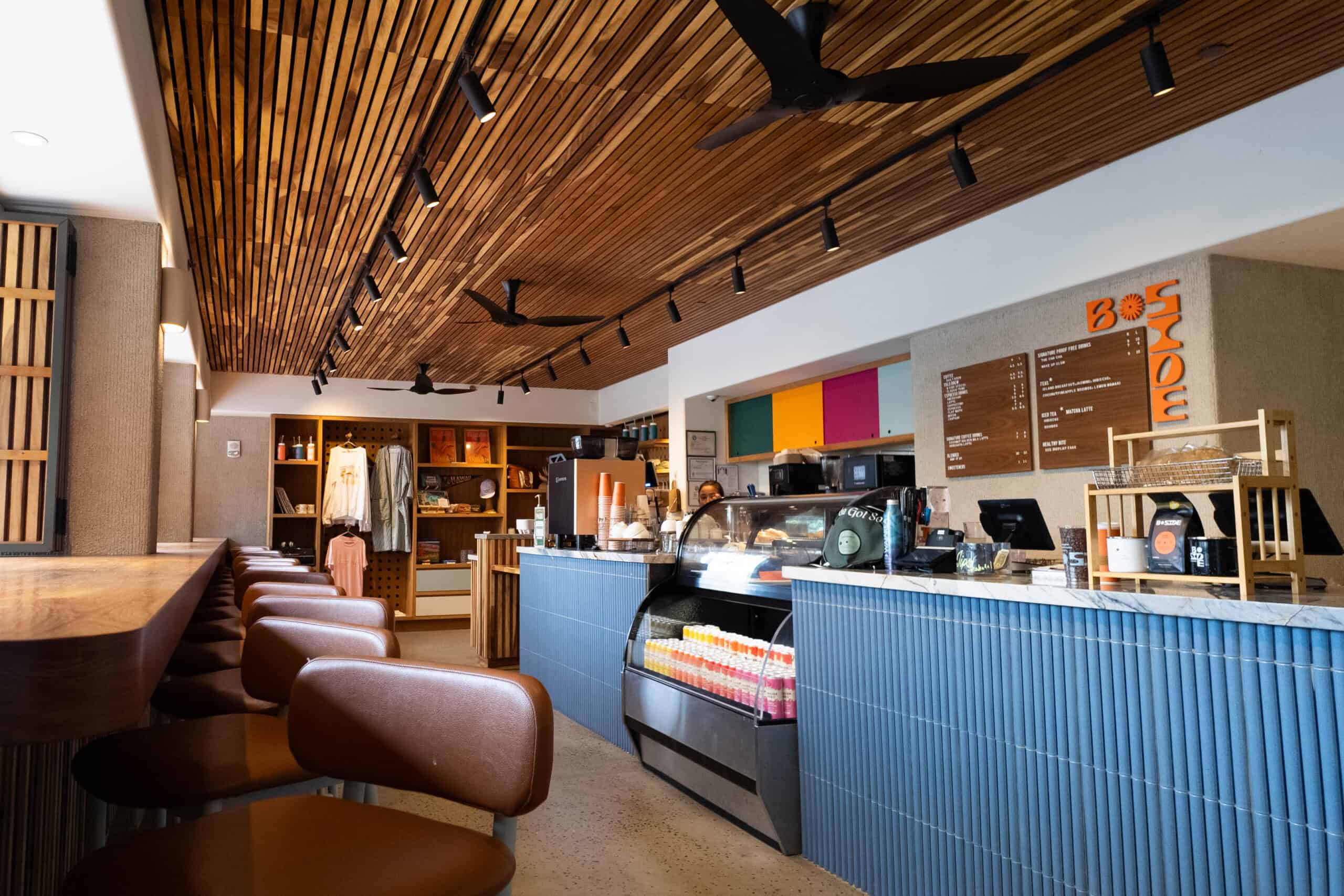 A coffee shop with brown chairs and a blue coffee bar