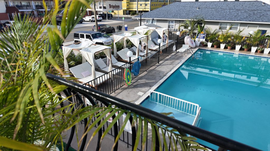 Tropical plants and white cabanas surrounding an inviting looking hotel pool