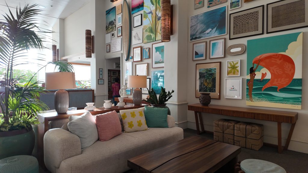 A colorful hotel lobby with tropical plants and artwork.