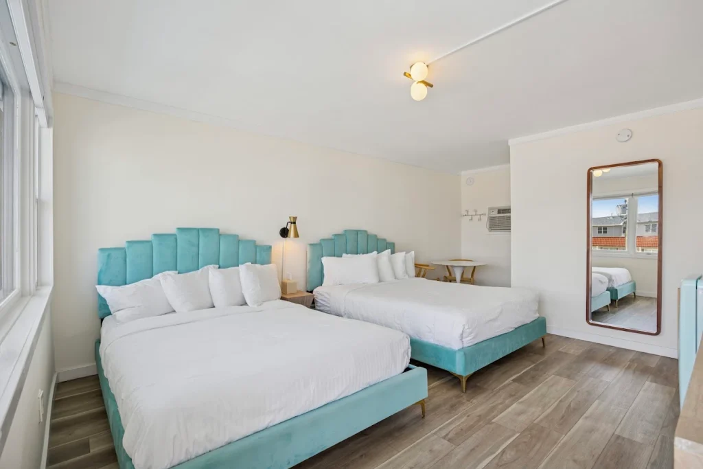 A bright hotel room with two beds and turquoise bed frames in Wildwood NJ 